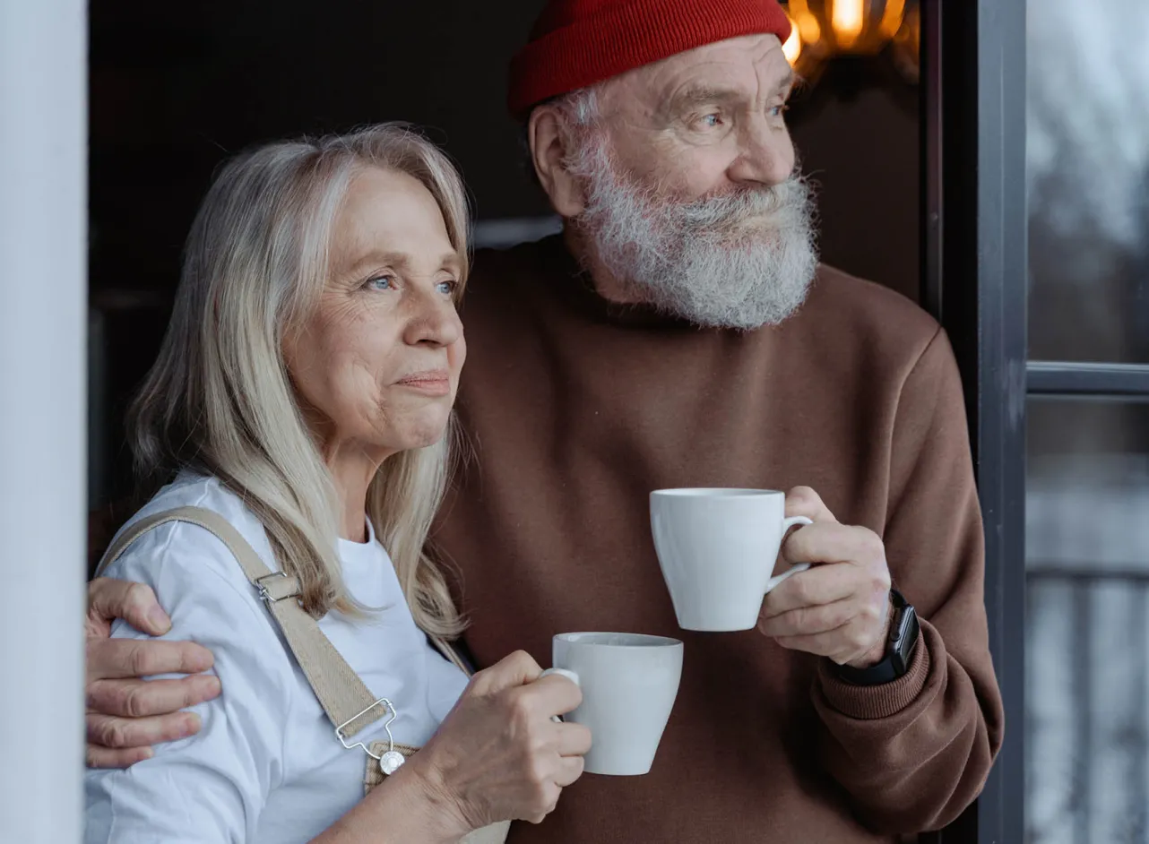 couple looking outside holding cups 